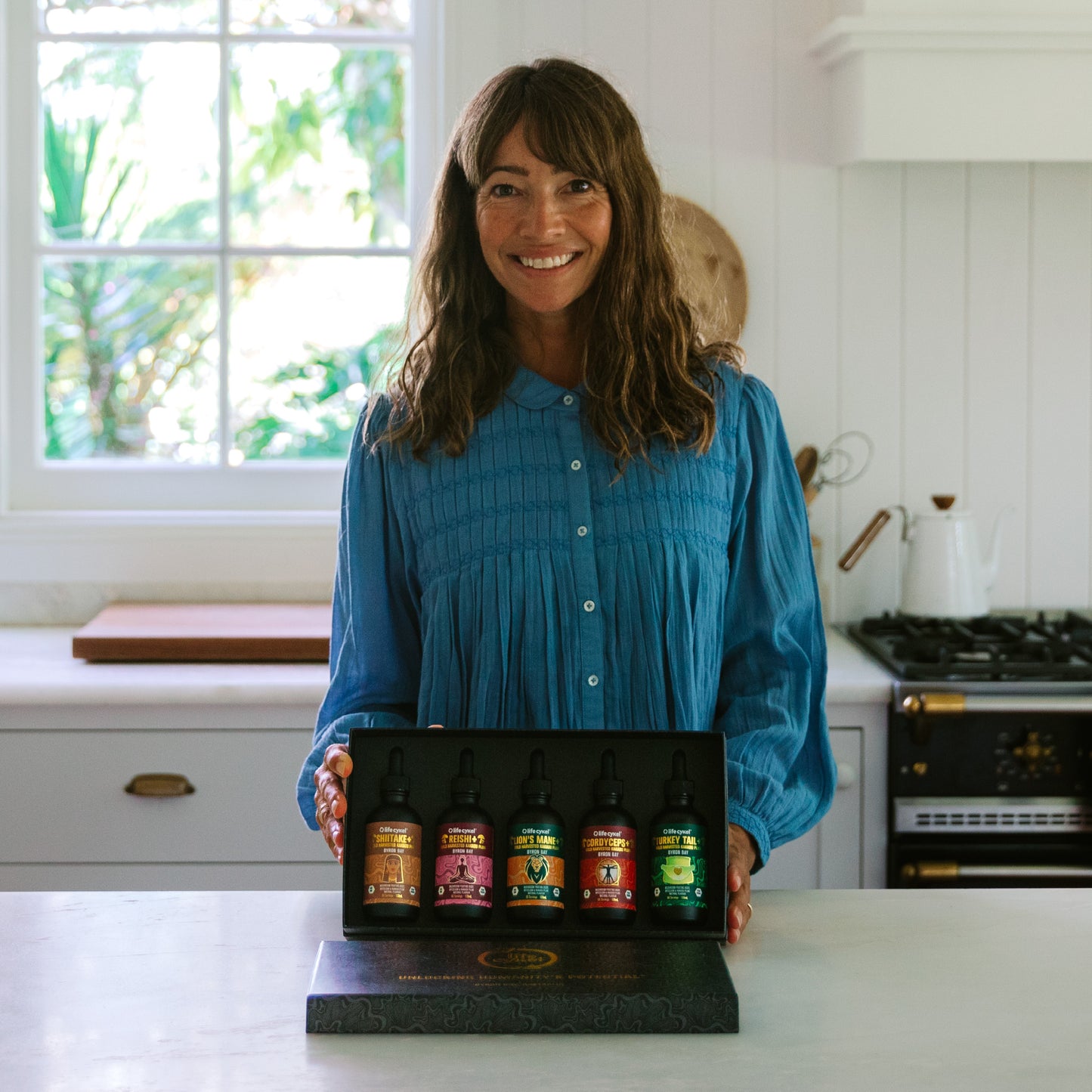 Woman introducing Lifecykel Biohacker Set mushroom extracts in the kitchen counter