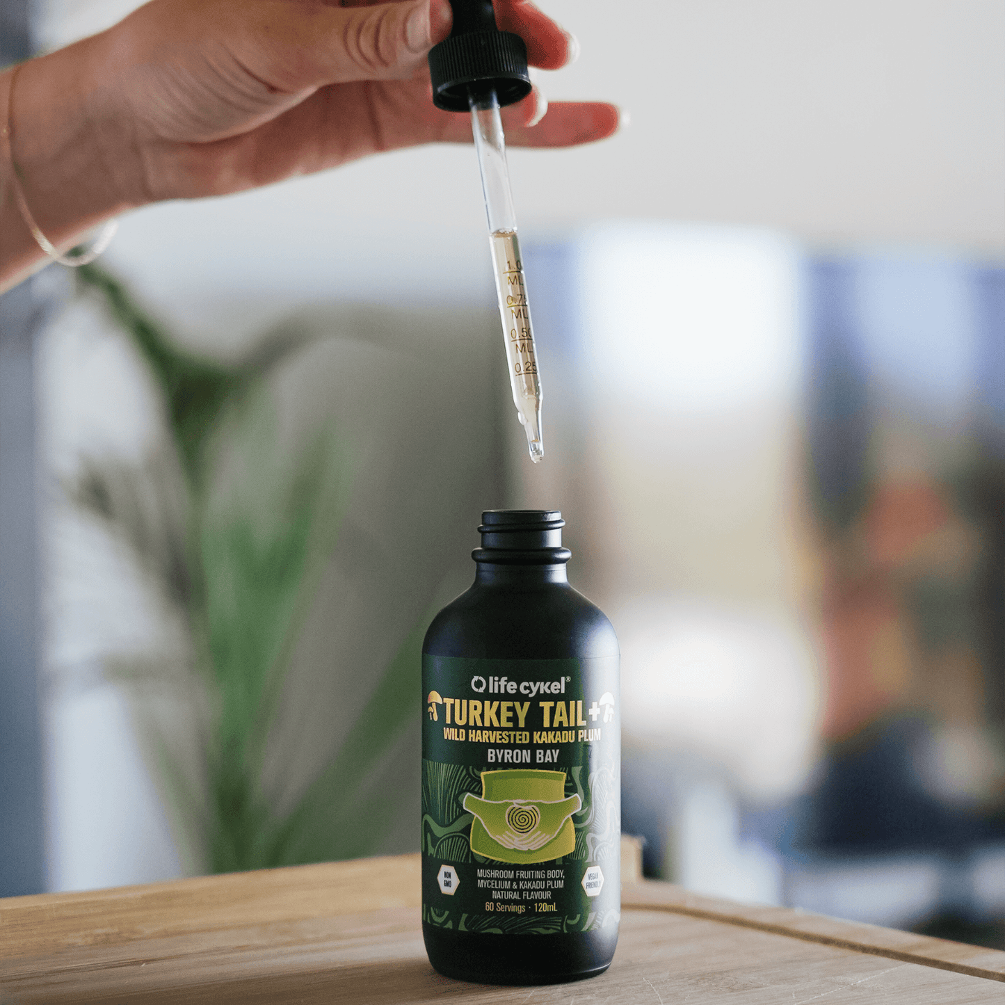 Bottle of Lifecykel Turkey Tail mushroom extracts with dropper on a wooden surface