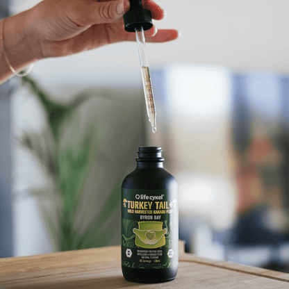 Bottle of Lifecykel Turkey Tail mushroom extracts with dropper on a wooden surface